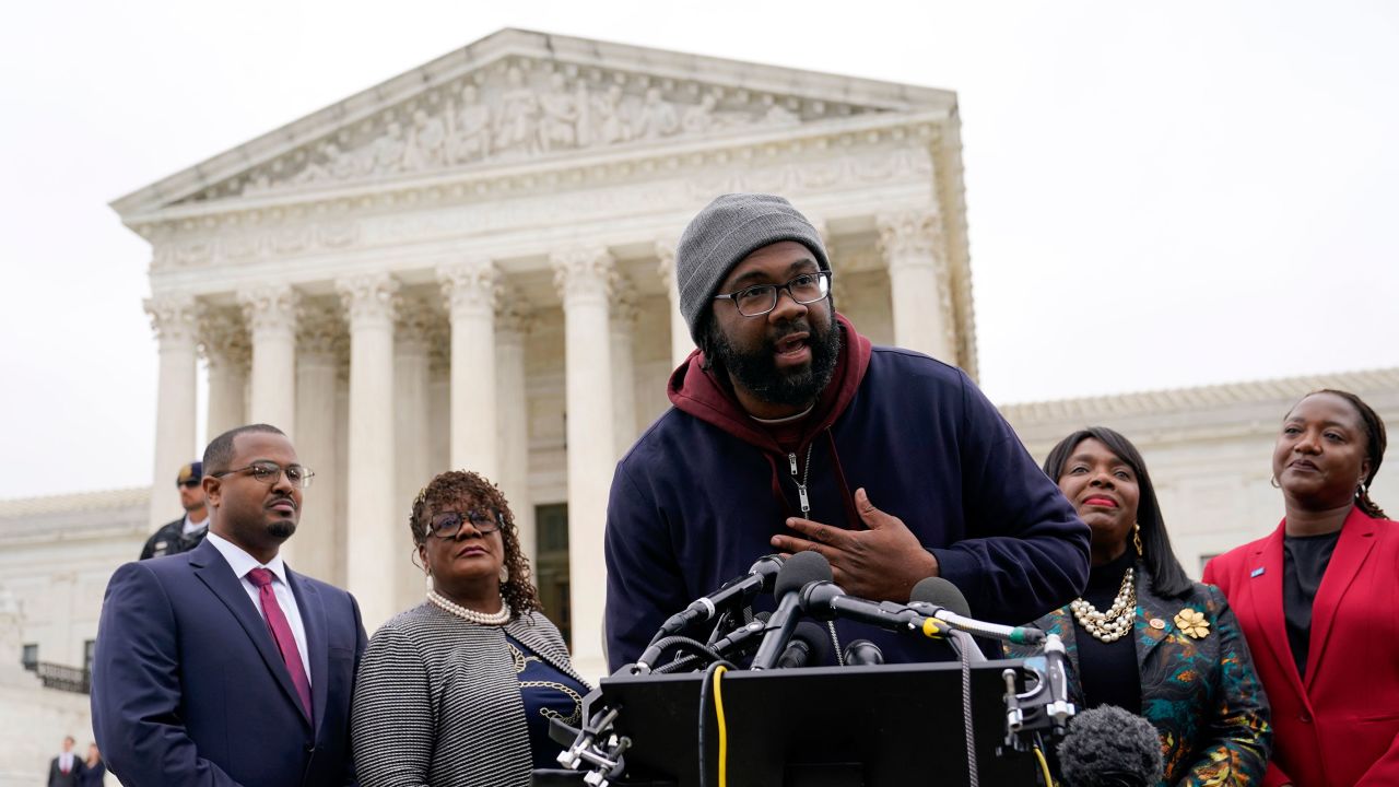 Evan Milligan, center, plaintiff in Merrill v. Milligan, an Alabama redistricting case that could have far-reaching effects on minority voting power across the United States, speaks with reporters following oral arguments at the Supreme Court in Washington, Oct. 4, 2022. 