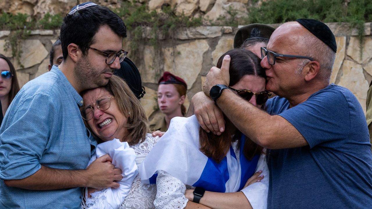 The mother (L), sister (R) and immediate family of Valentin (Eli) Ghnassia, 23, who was killed in a battle with Hamas militants at Kibbutz Be'eeri near the Israeli border with the Gaza Strip, react during his funeral,  October 12, 2023 in Jerusalem, Israel. 