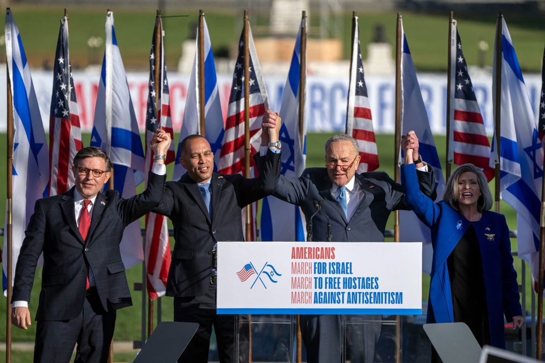 From left, House Speaker Mike Johnson, House Minority Leader Hakeem Jeffries, Senate Majority Leader Chuck Schumer and Sen. Joni Ernst join hands at the March for Israel on Tuesday. 