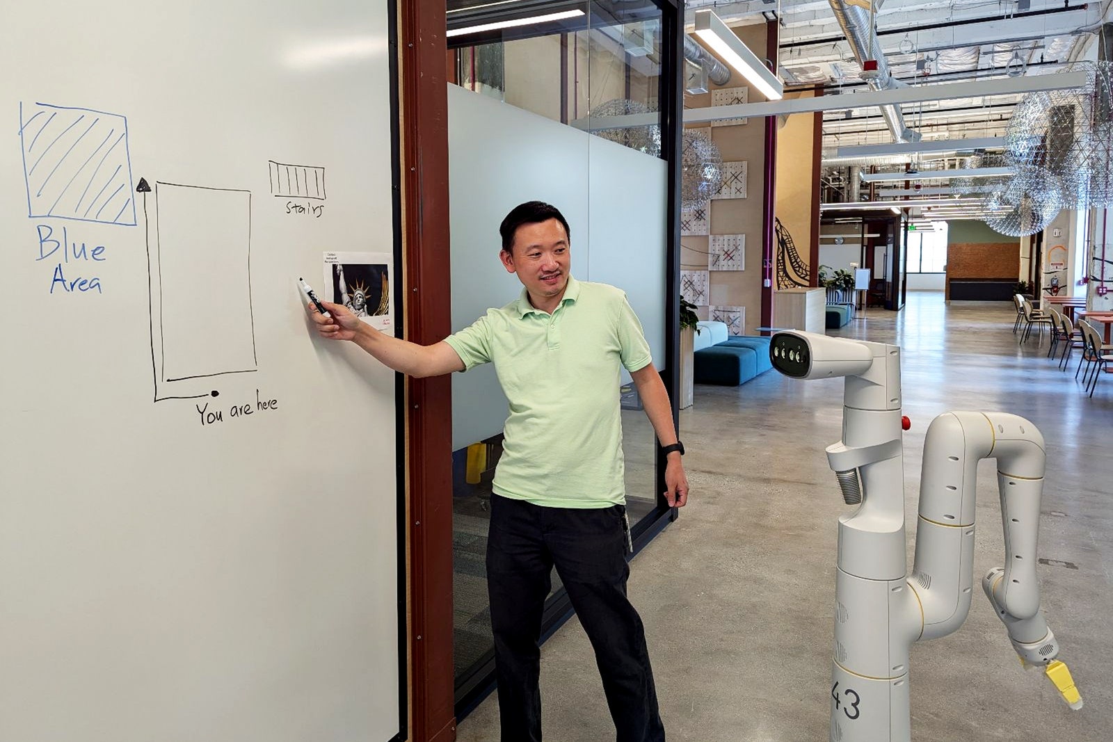 A photo of a Google DeepMind employee interacting with an AI robot.